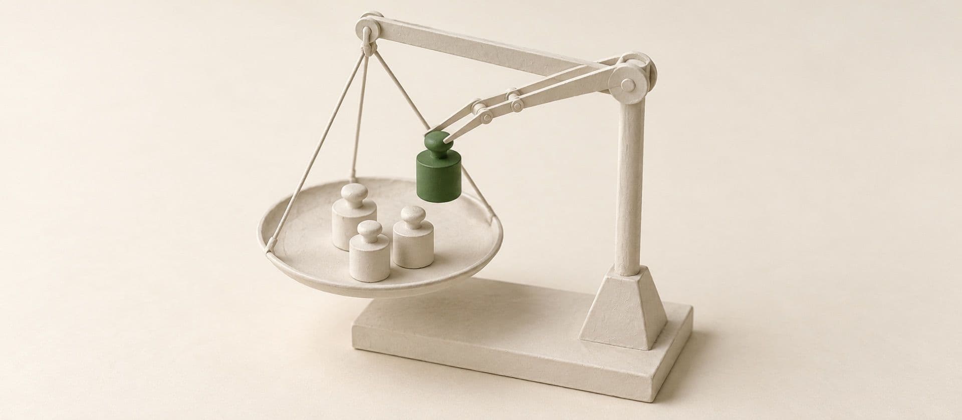 A cream study model of one pan of a balance scale with three small weights on it and a pair of tongs lowering a fourth, with the fourth weight in green.