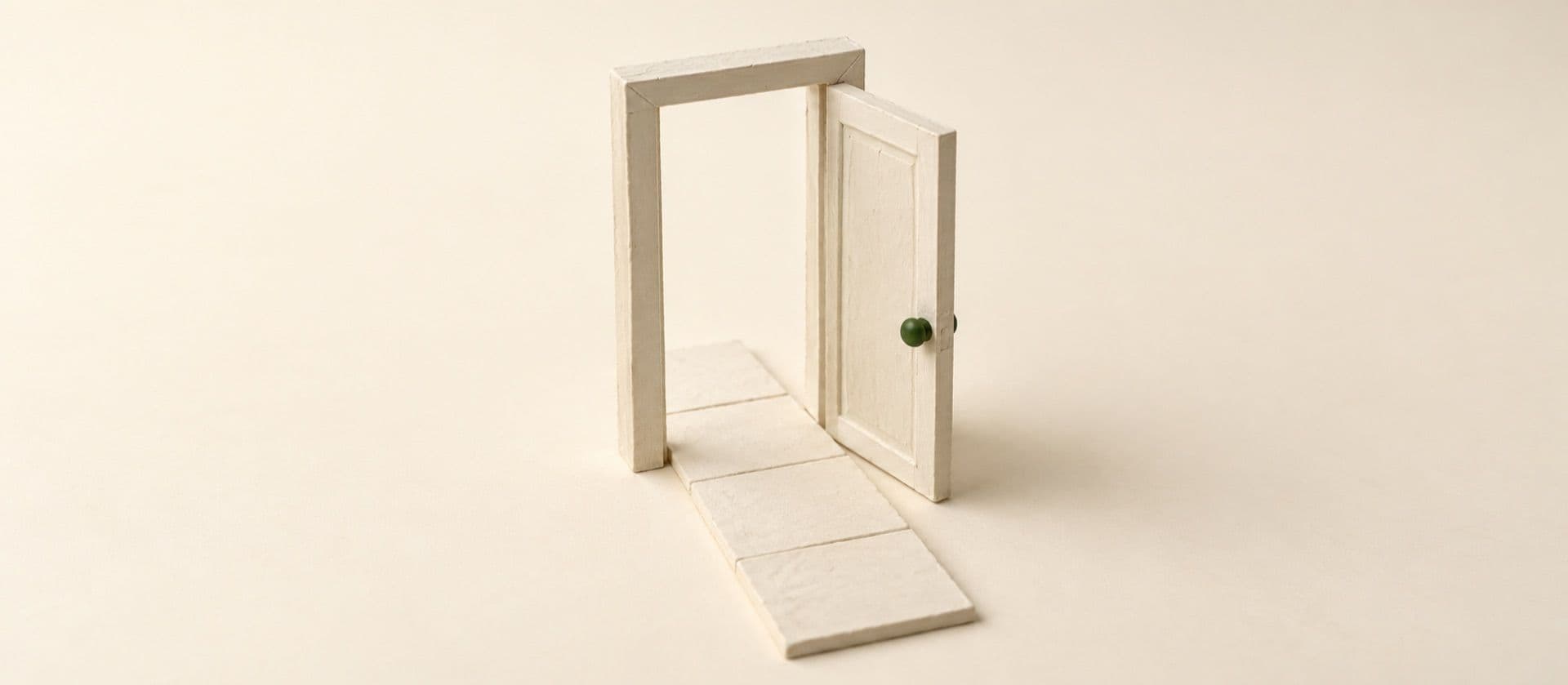 A cream study model of a single door standing open in its own freestanding frame, a short path running through it, with the doorknob in green.