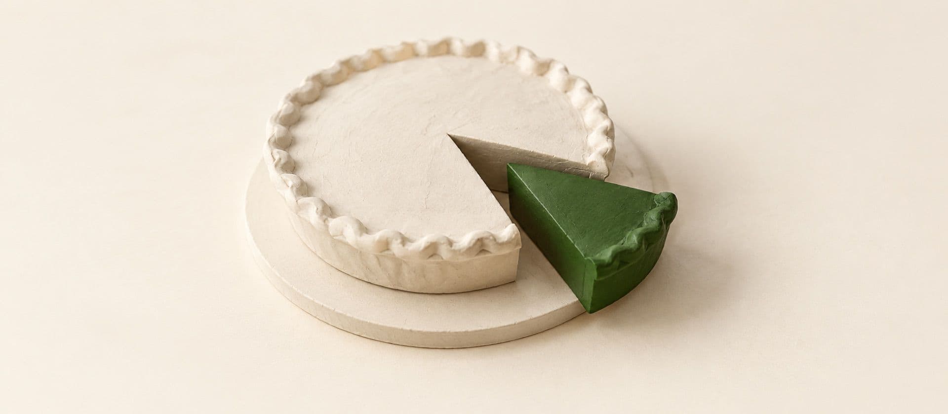 A cream study model of a round pie on a plain board with one wedge cut and pulled slightly out, with the pulled wedge in green.